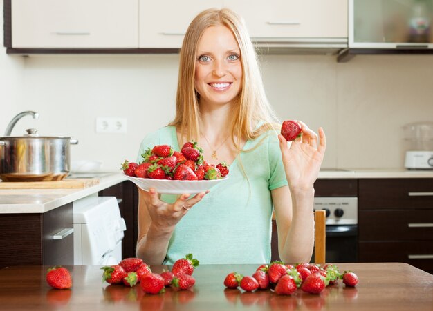 femme au foyer avec des fraises à la cuisine