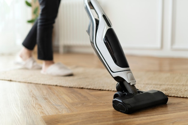 Femme au foyer passant l'aspirateur sur un parquet