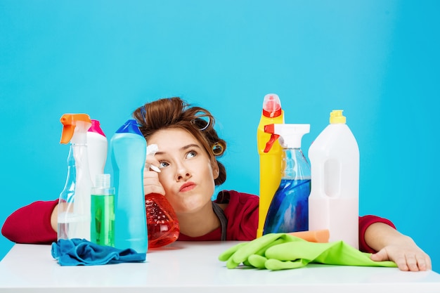 Femme au foyer semble fatiguée et plongée dans ses pensées pendant le nettoyage et le lavage