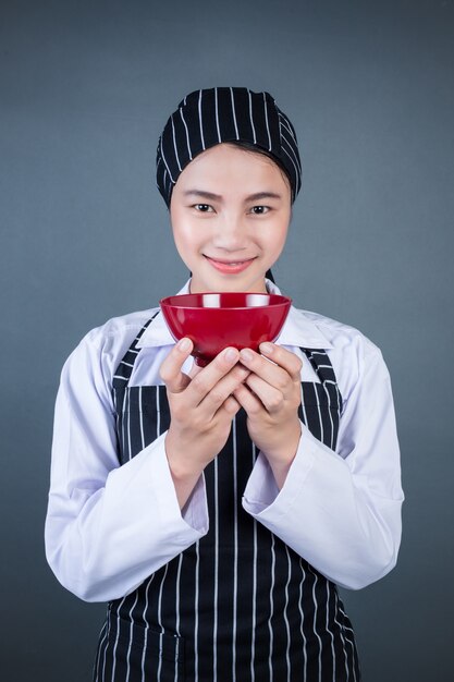 Une femme au foyer tenant une assiette vide avec de la nourriture