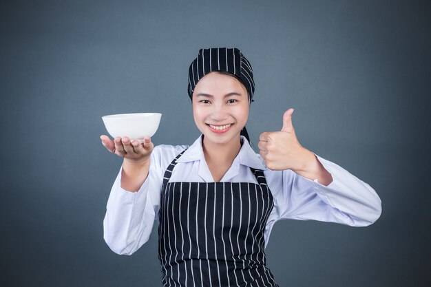 Une femme au foyer tenant une assiette vide avec de la nourriture