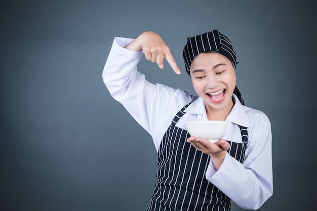 Une femme au foyer tenant une assiette vide avec de la nourriture