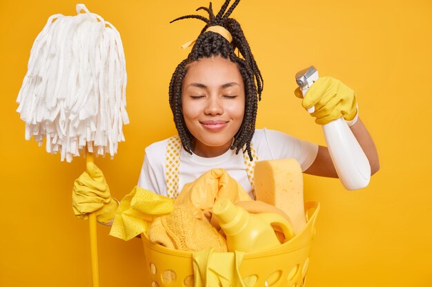Femme au foyer travailleuse ferme les yeux sourit agréablement aime nettoyer