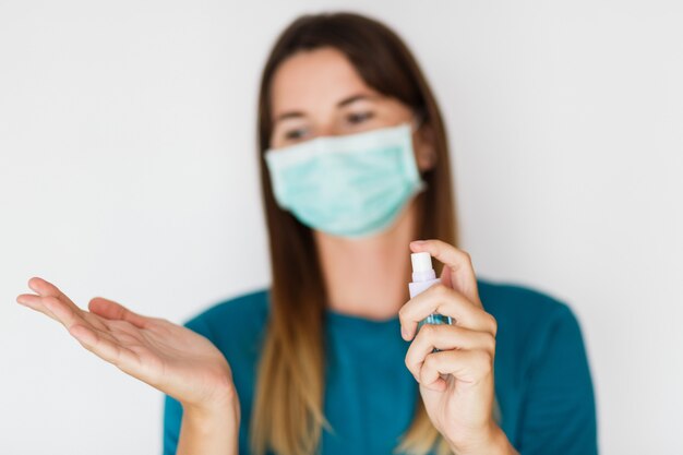 Femme Au Masque De Protection Se Laver Les Mains Avec Un Désinfectant Pour Les Mains