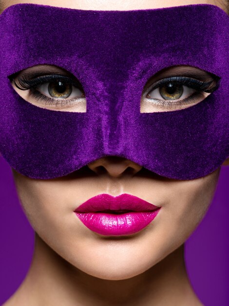 Femme au masque de théâtre violet sur le visage avec des lèvres violettes