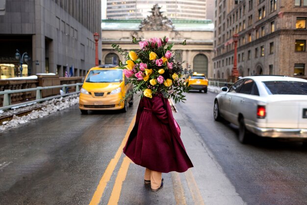 Femme au printemps tenant un bouquet de fleurs