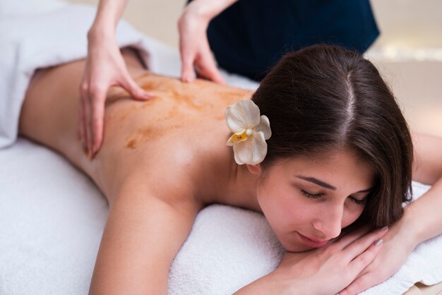 Femme au spa profitant d'un massage du dos