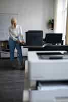 Photo gratuite femme au travail au bureau à l'aide d'une imprimante