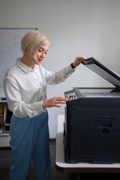 Femme au travail au bureau à l'aide d'une imprimante