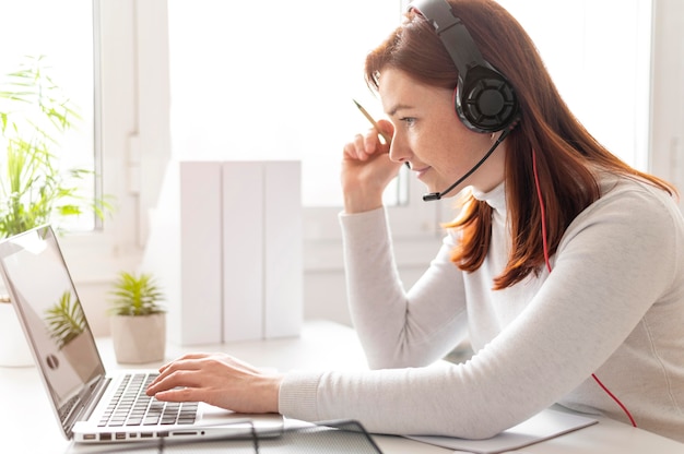 Femme au travail ayant un appel vidéo sur ordinateur portable