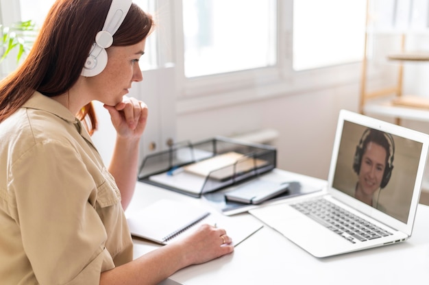 Femme au travail ayant un appel vidéo sur ordinateur portable