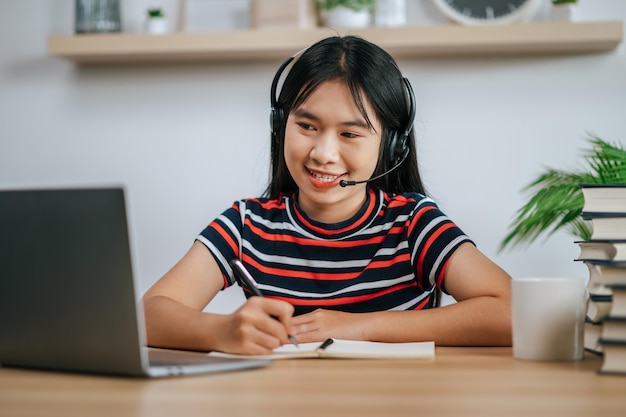 Femme au travail lisant un livre sur la table et portant des écouteurs