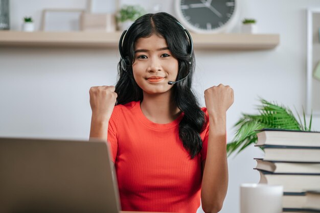 Femme au travail lisant un livre sur la table et portant des écouteurs