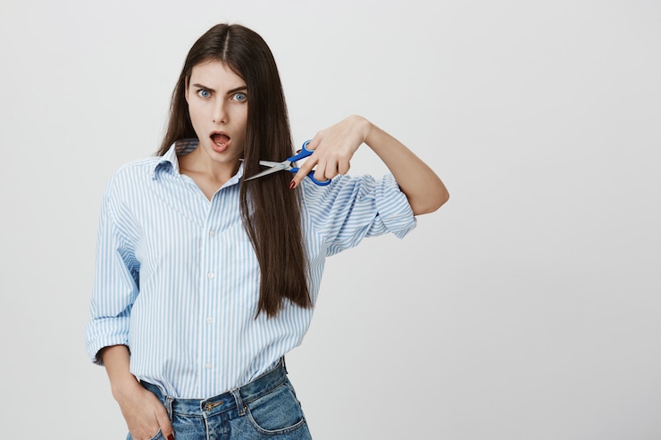 Photo gratuit une femme audacieuse et impertinente montre des ciseaux, se coupe les cheveux
