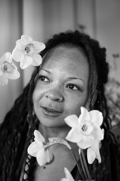 Femme authentique posant avec vue de côté de fleurs