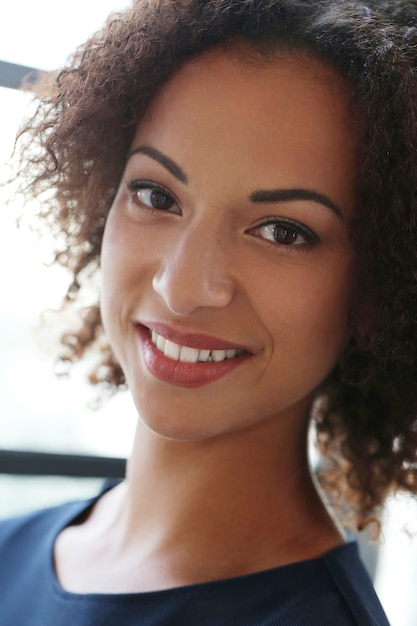 Femme aux cheveux bouclés et souriant