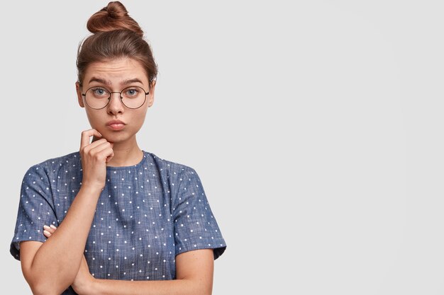 Femme aux cheveux en chignon portant un chemisier à pois