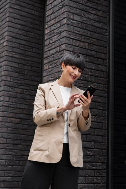 Femme aux cheveux courts tenant son téléphone