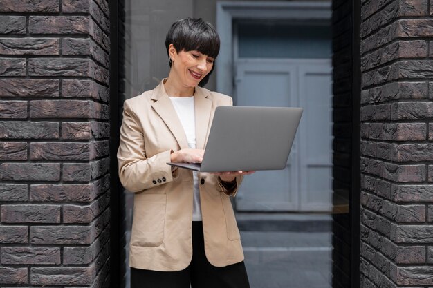 Femme aux cheveux courts vérifiant son ordinateur portable