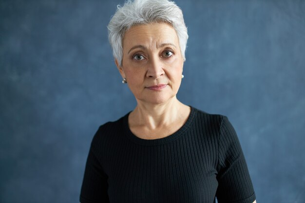 femme aux cheveux gris en t-shirt noir décontracté surpris