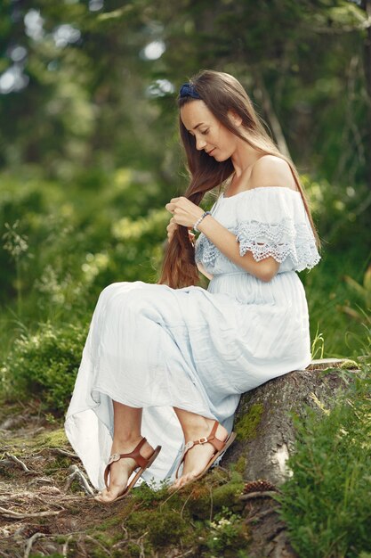 Femme aux cheveux longs. Dame en robe bleue. Fille avec une nature intacte.