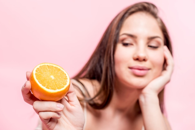 Femme aux cheveux sombres tenant en tranches d&#39;orange à la main