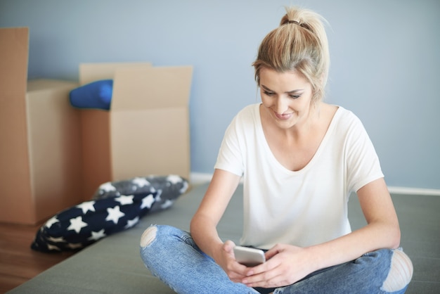 Femme aux jambes croisées avec smartphone