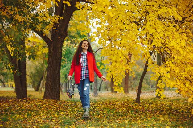 femme aux longs cheveux ondulés, profitant de l'automne dans le parc.