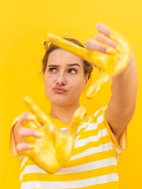 Femme aux mains peintes en jaune