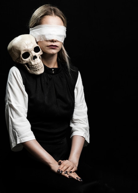 Femme aux yeux bandés et crâne humain