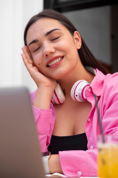 Photo gratuite femme ayant un appel vidéo sur un ordinateur portable dans un café