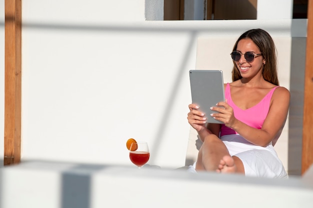 Photo gratuite femme ayant un appel vidéo sur sa tablette pendant ses vacances