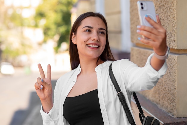 Photo gratuite femme ayant un appel vidéo sur smartphone tout en étant à l'extérieur de la ville