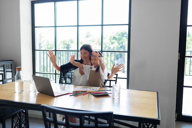 Femme ayant un appel vidéo avec son mari à côté de leur fille