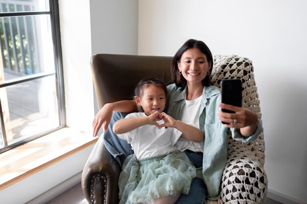 Femme ayant un appel vidéo avec son mari à côté de leur fille