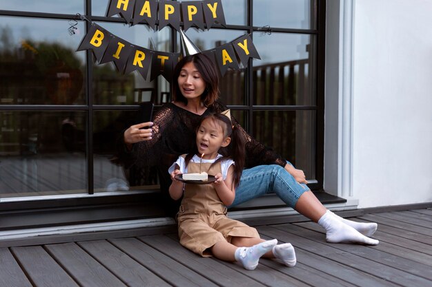 Femme ayant un appel vidéo avec son mari pour l'anniversaire de leur fille