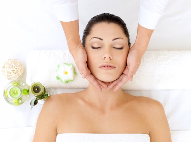 Femme ayant un massage de la tête dans le salon spa. Concept de traitement de beauté.