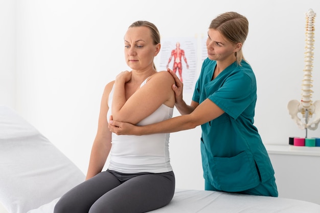 Femme ayant une séance de physiothérapie dans une clinique