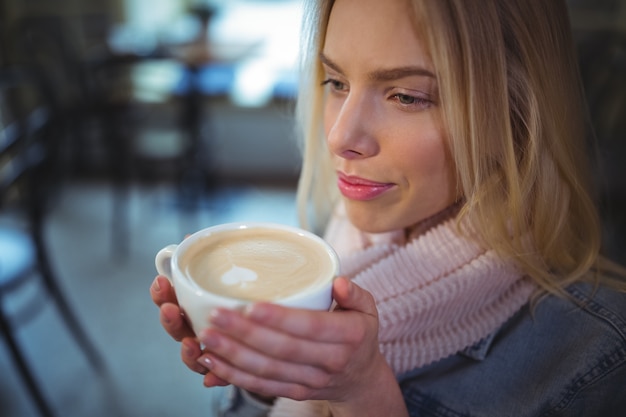 Femme ayant une tasse de café dans un café ©