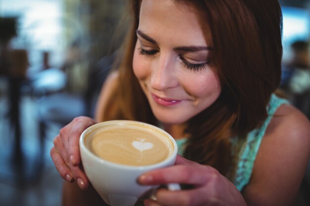 Femme ayant une tasse de café dans un café ©