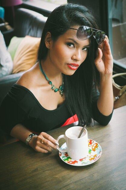 Femme ayant une tasse de café