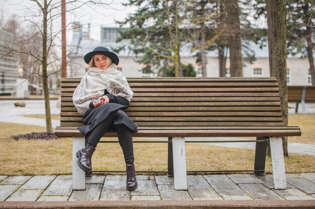 Femme sur banc en un jour pluvieux