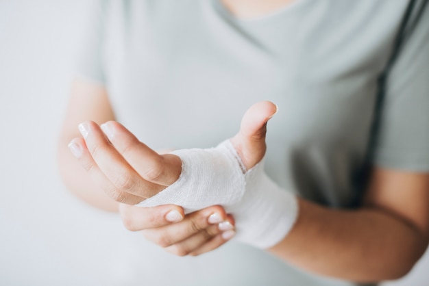 Femme avec un bandage de gaze enroulé autour de sa main