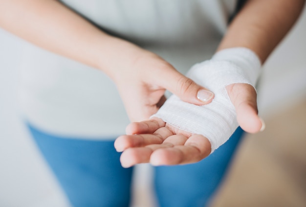 Femme avec un bandage de gaze enroulé autour de sa main