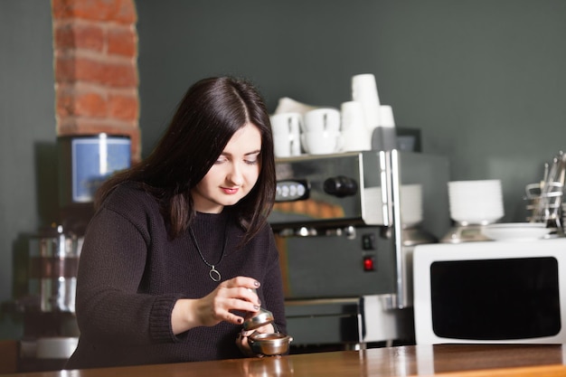 Femme barista pendant la préparation de l'espresso, utilisez le presse-café