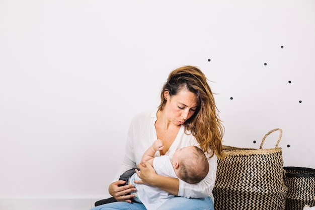 Photo gratuite femme bascule bébé près des paniers