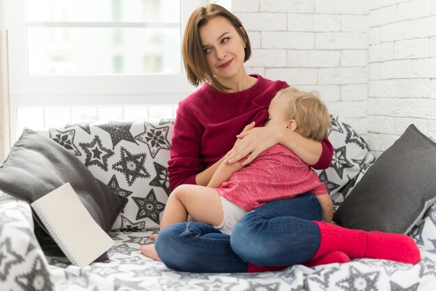 Femme avec un bébé sur sofá