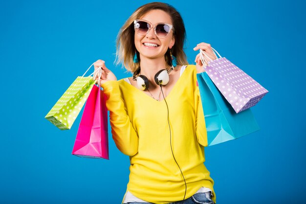 Femme belle jeune hipster, tenant des sacs en papier coloré