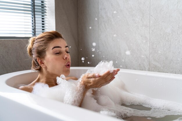 Femme bénéficiant d'un bain moussant relaxant