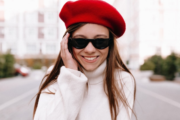 femme en béret rouge posant dans la rue